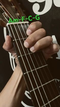 a person playing an acoustic guitar with the number 99 on it's fret