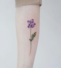 a small purple flower on the right thigh