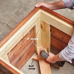 a person using a drill to attach the top of a wooden structure with two screws