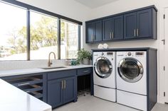 a washer and dryer in a kitchen with blue cabinets