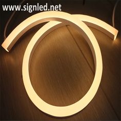 two white circular lights sitting on top of a wooden floor