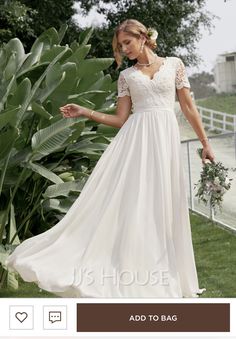 a woman in a long white dress standing on grass with her hand out to the side