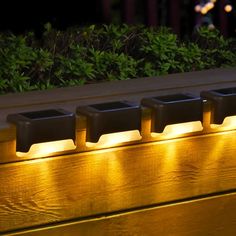 a row of lights that are on the side of a bench