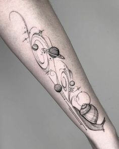 a person with a black and white tattoo on their arm that has an image of saturn