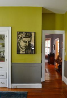 a living room with yellow walls and white doors, hardwood floors and pictures on the wall