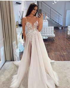 a woman taking a selfie while wearing a wedding dress in front of a mirror