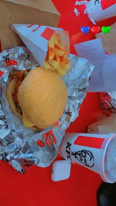 a hamburger and ketchup sitting on top of tin foil