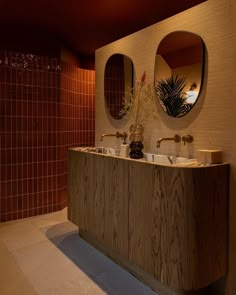 a bathroom with two sinks and mirrors on the wall