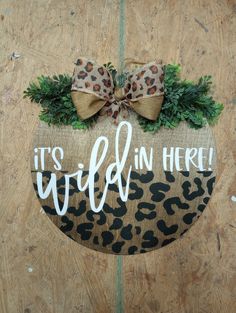 a door hanger that says it's wild in here with a leopard print bow