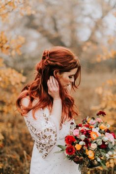 a woman with red hair holding a bouquet of flowers