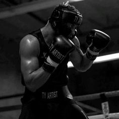 a man wearing boxing gloves standing in a ring