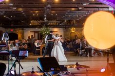 a bride and groom dance together in front of an audience at their wedding reception on the dance floor