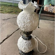 a white vase sitting on top of a sidewalk