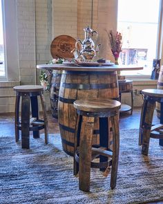 a wooden barrel table with stools around it