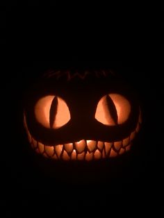 a jack o lantern with glowing eyes in the dark, looking like it has been carved into