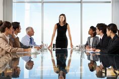 a woman standing in front of a group of business people