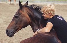 a woman sitting on top of a brown horse