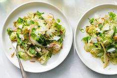 two white plates filled with salad on top of a table