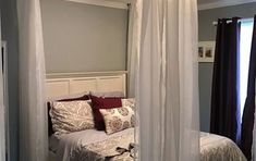 a bedroom with four poster bed and curtains