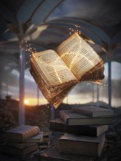 an open book is suspended from the ceiling by string lights on top of stacked books