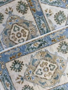 an old rug is laying on the floor with blue and beige colors, including flowers