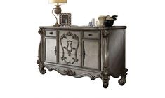 an ornately decorated sideboard with a lamp on top