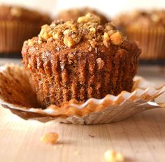 a muffin sitting on top of a wooden table next to other muffins