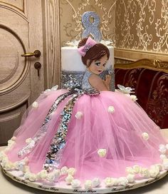 a birthday cake with a doll on top and pink tulle skirt in the shape of a ball gown