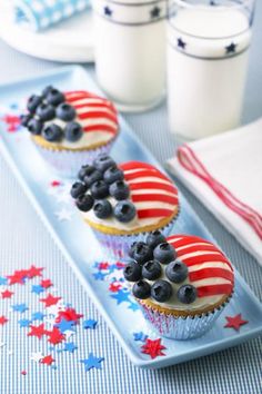 patriotic cupcakes with blueberries and strawberries on them sitting on a plate