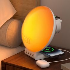 an alarm clock sitting on top of a nightstand next to a phone and headboard