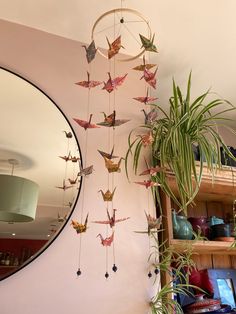 a mirror hanging on the wall next to a potted plant