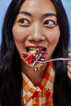 a woman eating a salad with a fork