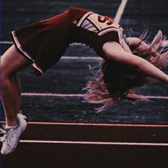 a woman doing a handstand on a tennis court