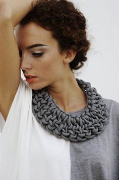 a woman wearing a gray knitted necklace