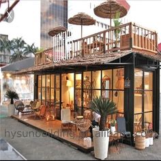 a doll house with lots of furniture and umbrellas on the roof, in front of a tall building