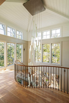 a large open floor plan with wood floors and white walls, chandelier hanging from the ceiling