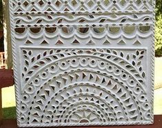 an intricately designed white box sitting on top of a wooden table