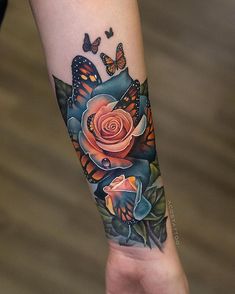 a woman's arm with a rose and butterflies on it