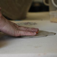 a person's hand is on top of a piece of paper that has been folded