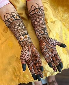 two hands with henna tattoos on them