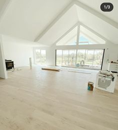 an empty living room with white walls and wood flooring in the middle of it