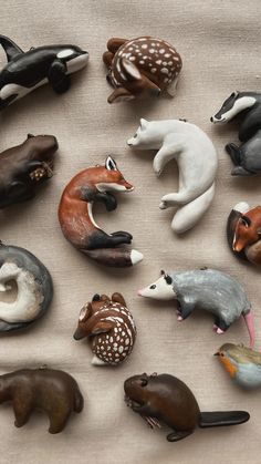 various animal figurines are arranged on a tablecloth with white and black dots