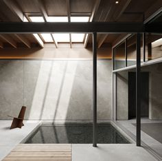 an empty room with wooden flooring and concrete walls, along with a bench in the foreground