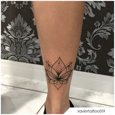 a woman's leg with a lotus tattoo on the lower part of her leg