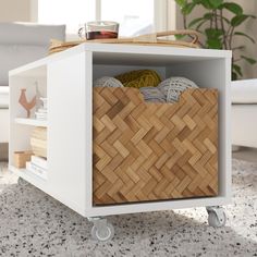 a basket sitting on top of a white table next to a couch in a living room