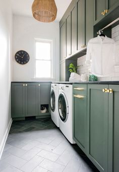 a washer and dryer in a room with green cabinets