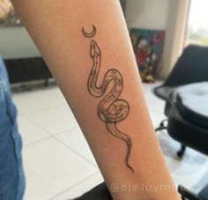 a woman's arm with a snake tattoo on it