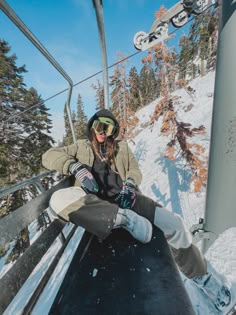 a woman sitting on the side of a ski lift