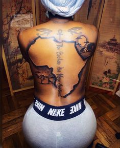 the back of a woman's body with tattoos on it