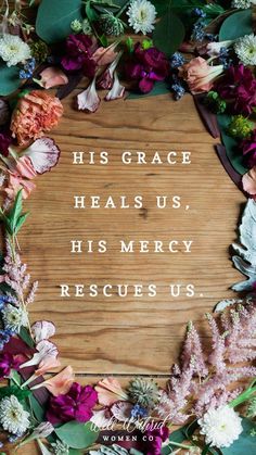 a wooden sign surrounded by flowers and greenery with the words his grace heals us, his merry rescueus